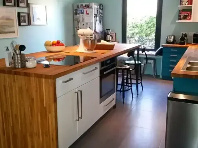 Rénovation cuisine sur-mesure : îlot central bois et blanc, plan de travail fonctionnel.