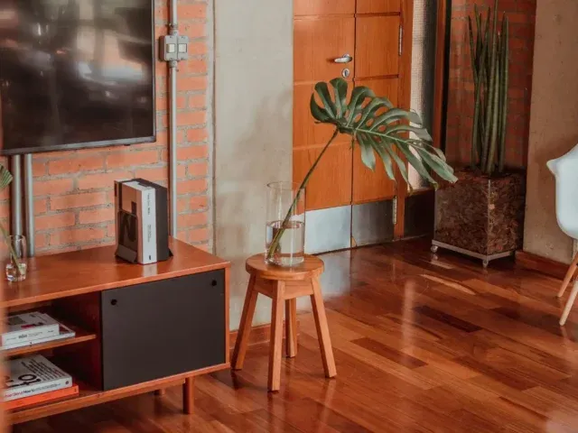 Aménagement salon de style industriel : mur en brique, pose de parquet et mobilier bois