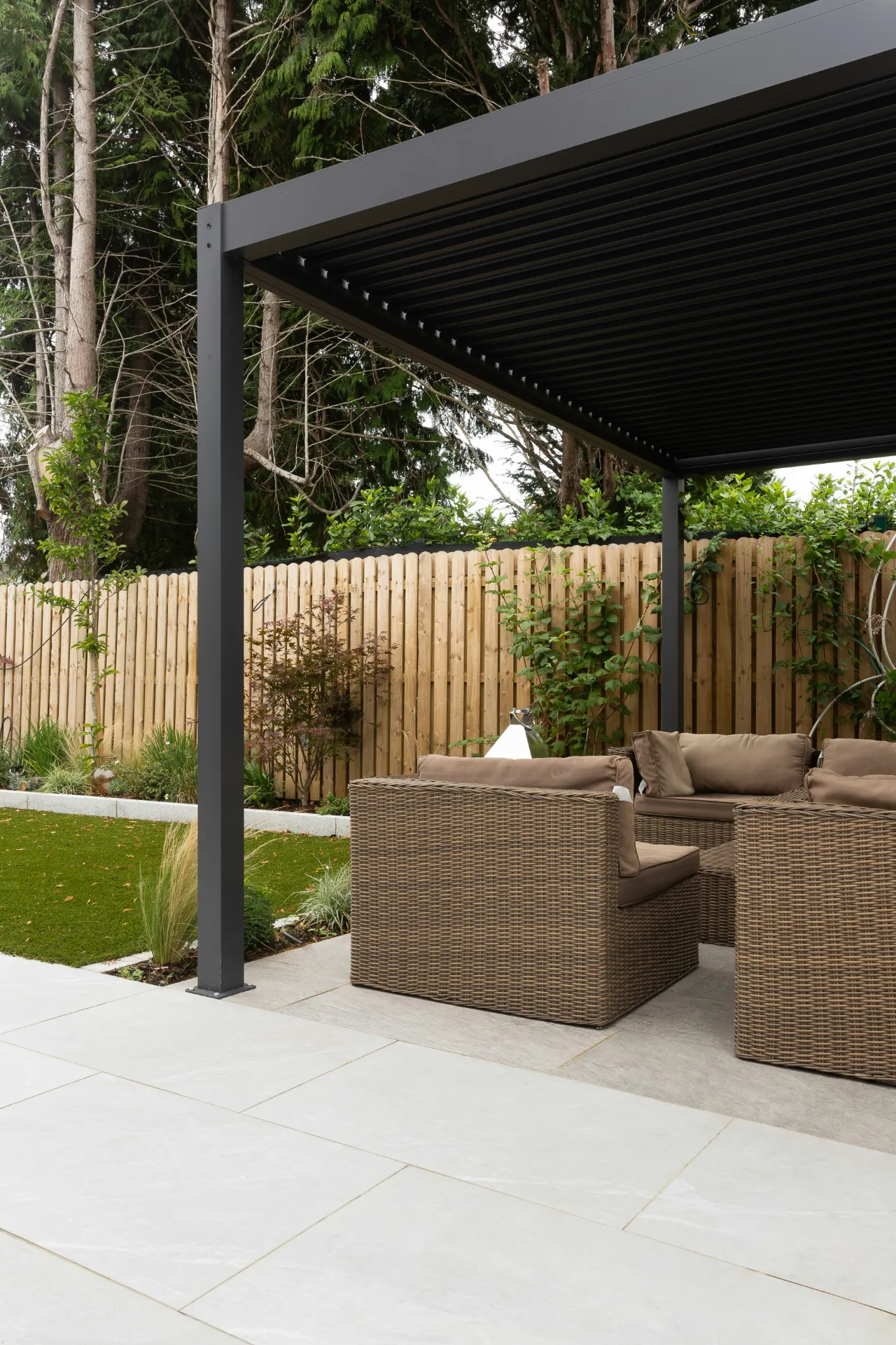 Aménagement terrasse sur-mesure : pose de dallage, pergola moderne anthracite et salon de jardin
